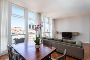 a living room with a couch and a table with flowers at Unhotel - Apartamento Familia Design Ipanema, Perto da Praia in Rio de Janeiro