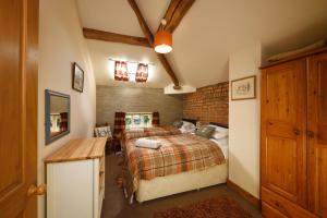 a bedroom with two beds and a brick wall at The Coach House in Oswestry