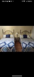a bedroom with two beds with blue and white pillows at Casa Pueblo bonito in Bernal