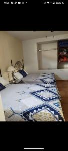 a bedroom with a bed with a blue and white quilt at Casa Pueblo bonito in Bernal