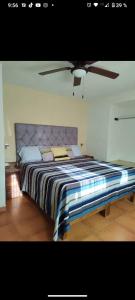 a bedroom with a large bed with a ceiling fan at Casa Pueblo bonito in Bernal +11 photos