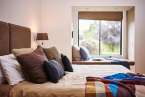 a bedroom with a bed with pillows and a window at Parehua Resort in Martinborough