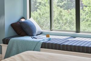 a window seat with a pillow in front of a window at Parehua Resort in Martinborough  +80 photos