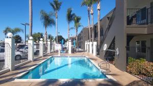 a swimming pool in front of a building with palm trees at SureStay Hotel by Best Western Chula Vista San Diego Bay in Chula Vista