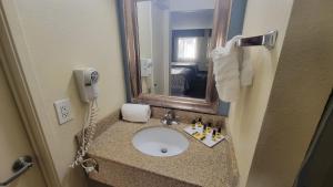 a bathroom with a sink and a mirror at SureStay Hotel by Best Western Chula Vista San Diego Bay in Chula Vista +14 photos