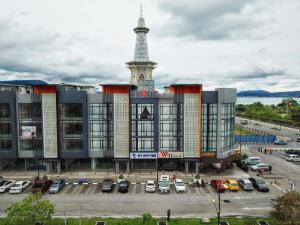 un edificio con una torre en medio de un aparcamiento en We Hotel Langkawi, en Kuah
