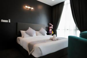 a bedroom with a large white bed with a window at We Hotel Langkawi in Kuah