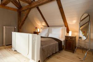 ein Schlafzimmer mit einem Bett und einem Spiegel im Dachgeschoss in der Unterkunft Gutshaus Lexow in Lexow