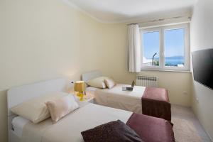 a hotel room with two beds and a window at House GOLD POINT in Ičići