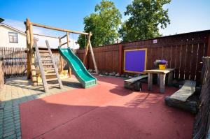 a playground with a slide and a table at Veldzes Nams in Ventspils