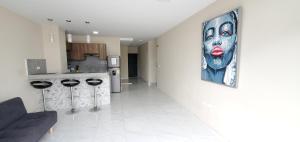 a living room with a painting of a woman on the wall at NCG SUITE Centro in Guayaquil