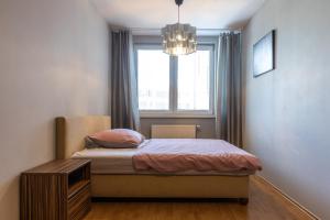 um pequeno quarto com uma cama e uma janela em Apartmán v Aleji em Bratislava