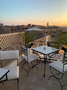 a patio with tables and chairs on a balcony at Riad Dollar Des Sables & Spa in Marrakesh