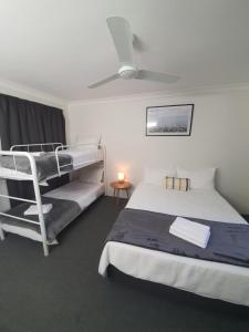 a bedroom with two bunk beds and a lamp at Sun City Motel in Bundaberg