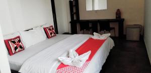 a bedroom with a white bed with a red and white blanket at KINGS GATE Airport TRANSIT HOTEL in Katunayaka