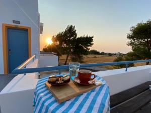 a table with a cup and a plate of food on a balcony at Marmaraki Village House & Apartments in Kardamaina