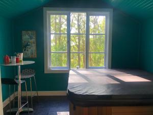 a blue room with a bed and a window at Olinda Forest Retreat with Spa in Olinda