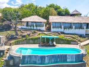 a swimming pool in front of a house at Theodor at Labuan Bajo in Labuan Bajo