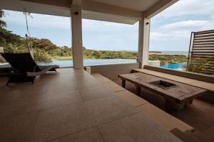 a patio with a table and a bench and a pool at MARINX POOLVILLA NAKANDAKARI in Nanjo