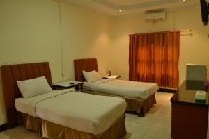 Tempat tidur dalam kamar di Malibou Hotel