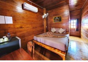 a bedroom with a bed in a wooden room at Perfect Resort Sukhothai & motorbikes for rent & bicycles for rent in Sukhothai