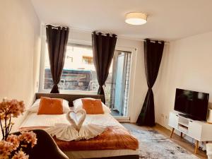 een slaapkamer met een bed met een hartkussen erop bij Central Cosy Apartment in Cologne in Keulen