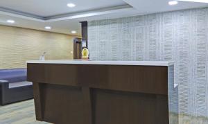 a lobby with a reception counter and a couch at Treebo Trend Raj Inn Lalpur in Rānchī