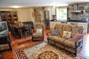 sala de estar con sofá y TV y cocina en Casa de Barreiros Camélias de Basto en Lamelas