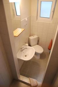 a small bathroom with a toilet and a sink at Beluga in Šventoji