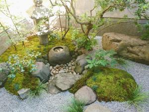 a garden with rocks and plants and a tree at Ryokan Tanoya in Kyoto +52 photos