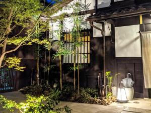 un bâtiment avec des plantes sur son côté dans l'établissement Ryokan Tanoya, à Kyoto