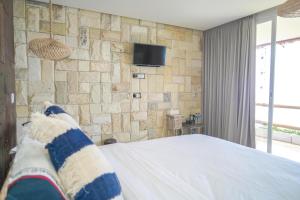 a bedroom with a stone wall and a bed at Theodor at Labuan Bajo in Labuan Bajo