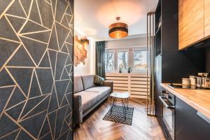 a living room with a couch and a kitchen at Hexagon Studio in Wrocław
