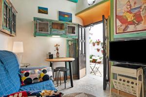 un salon avec un canapé bleu et une télévision dans l'établissement Casa Lola, à Vejer de la Frontera