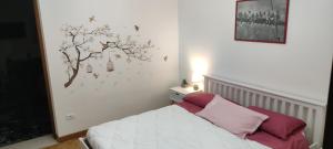 1 dormitorio con 1 cama con un árbol en la pared en Appartameto Casa Summano en Santorso