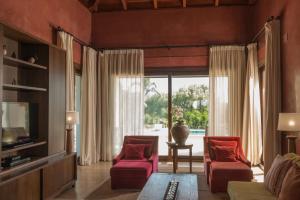 a living room with two red chairs and a tv at Villa Violeta in Benalup Casas Viejas
