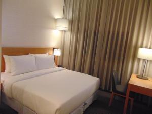 a bed in a hotel room with a desk and a bed sidx sidx at The Vern at BLVD in Nashik