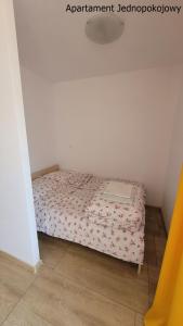 małą sypialnię z łóżkiem w pokoju w obiekcie Osada Portowa Krynica Morska w mieście Krynica Morska