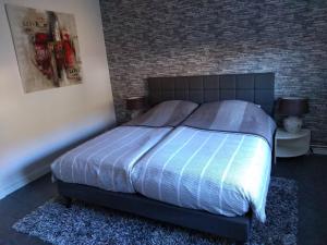 ein Bett in einem Schlafzimmer mit Ziegelwand in der Unterkunft Haus Christoffel Wieda in Wieda