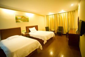 a hotel room with two beds and a television at GreenTree Inn Shanghai Meilan Lake Hutai Road Express Hotel in Baoshan