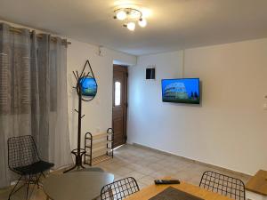 a living room with a table and a tv on the wall at Romantic maisonette in the heart of Pythagoreio RH door in Pythagoreio
