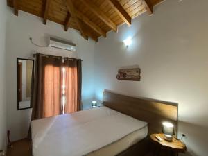 a bedroom with a large bed with a wooden headboard at Romantic maisonette in the heart of Pythagoreio RH door in Pythagoreio