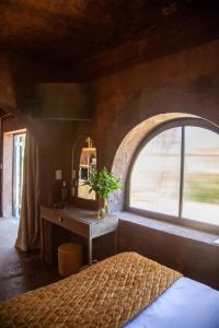 a bedroom with a bed and a window and a table at Le Héritage in Klein-Drakenstein