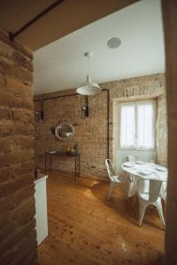 a dining room with a table and a brick wall at Calista Liston Corfu Apartment in Corfu Town