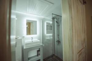 a white bathroom with a sink and a shower at Calista Liston Corfu Apartment in Corfu