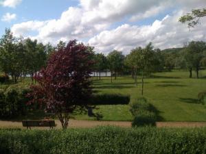 een park met een bank in het midden van een veld bij Hôtel du Val de Seine in Mantes-la-Jolie