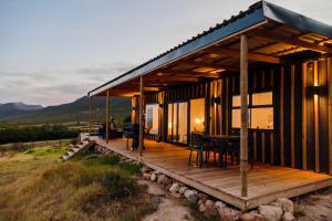 a house on a hill with a wooden deck at Springsteen Cabins in Tulbagh
