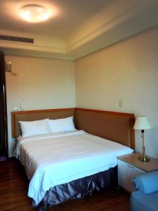 a bed in a hotel room with a large white bed at 雲雀高樓景觀公寓 in Taichung