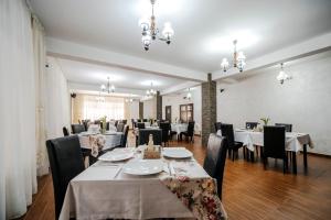 a dining room with white tables and black chairs at Pension Valeria in Voronet