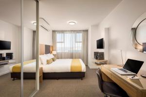 
a hotel room with a bed and a desk at Quest King William South in Adelaide
